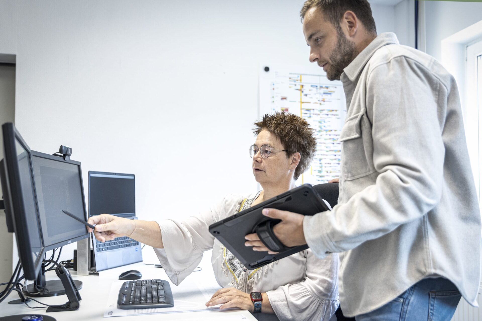 Zwei Personen arbeiten am Computer im Büro.