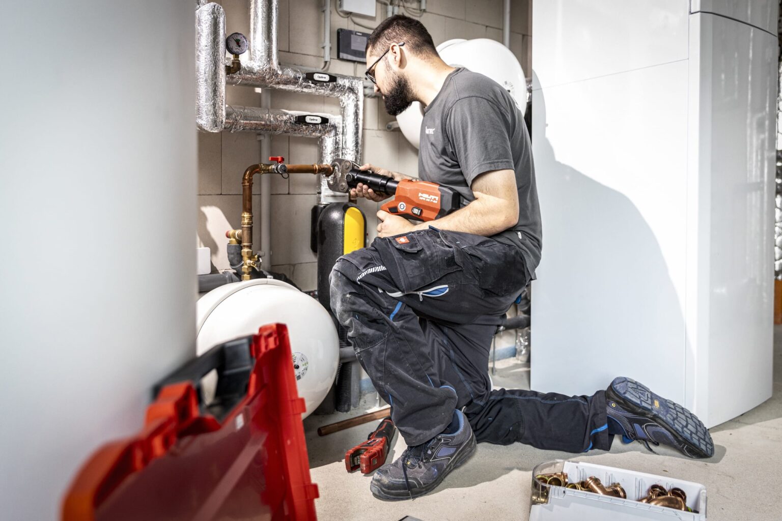 Installateur arbeitet an Heizungsanlage im Keller