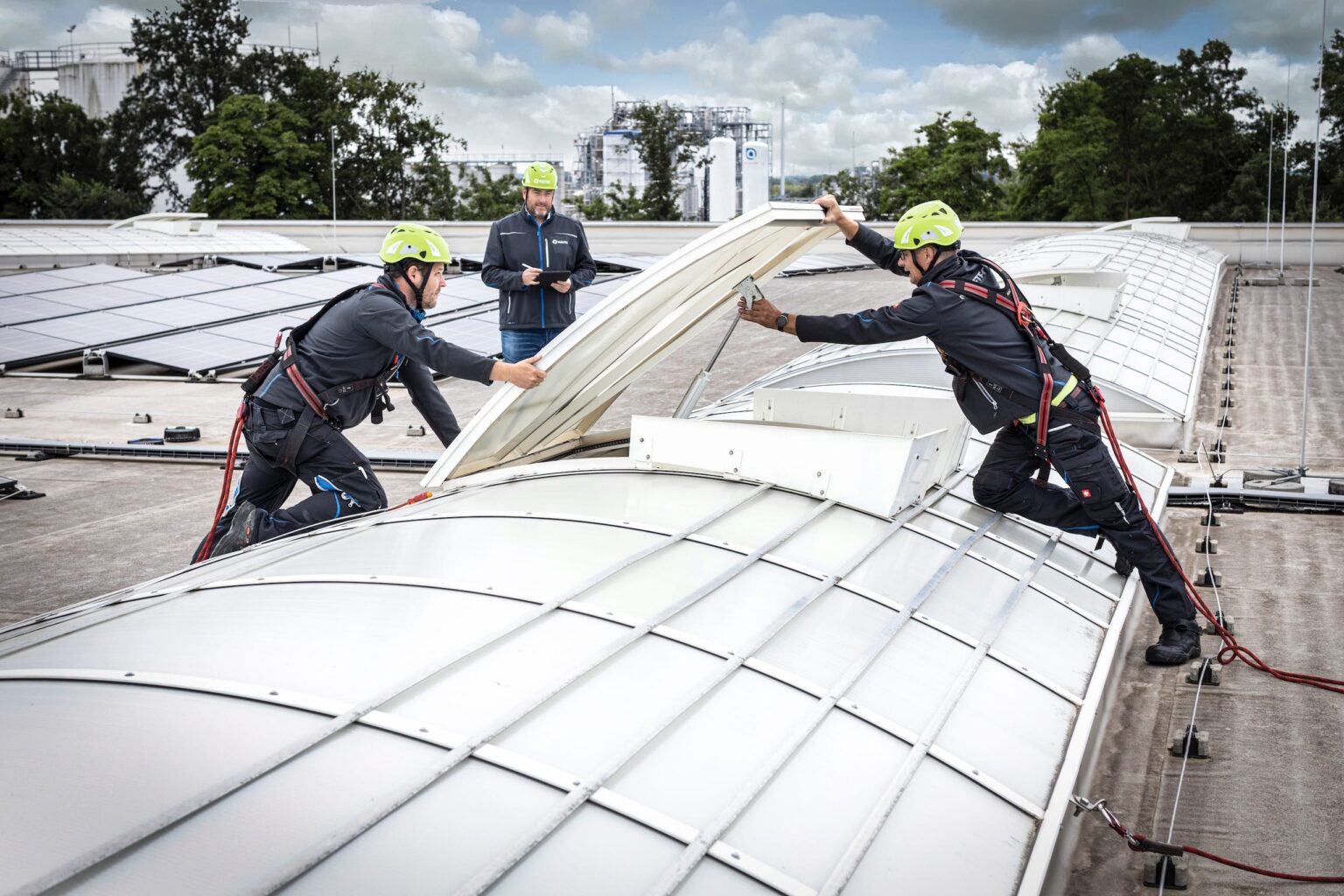 Arbeiter inspizieren Dach mit Solaranlagen