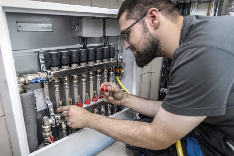 Elektriker arbeitet an Schaltkasten für Fußbodenheizung