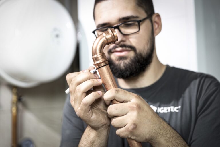 Installateur überprüft Kupferrohr mit Stift