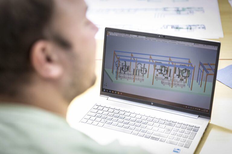 Mann betrachtet 3D-Plan auf Laptop-Bildschirm.