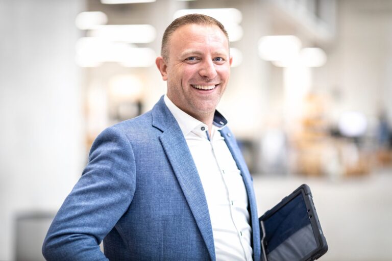 Lächelnder Mann im Anzug mit Tablet