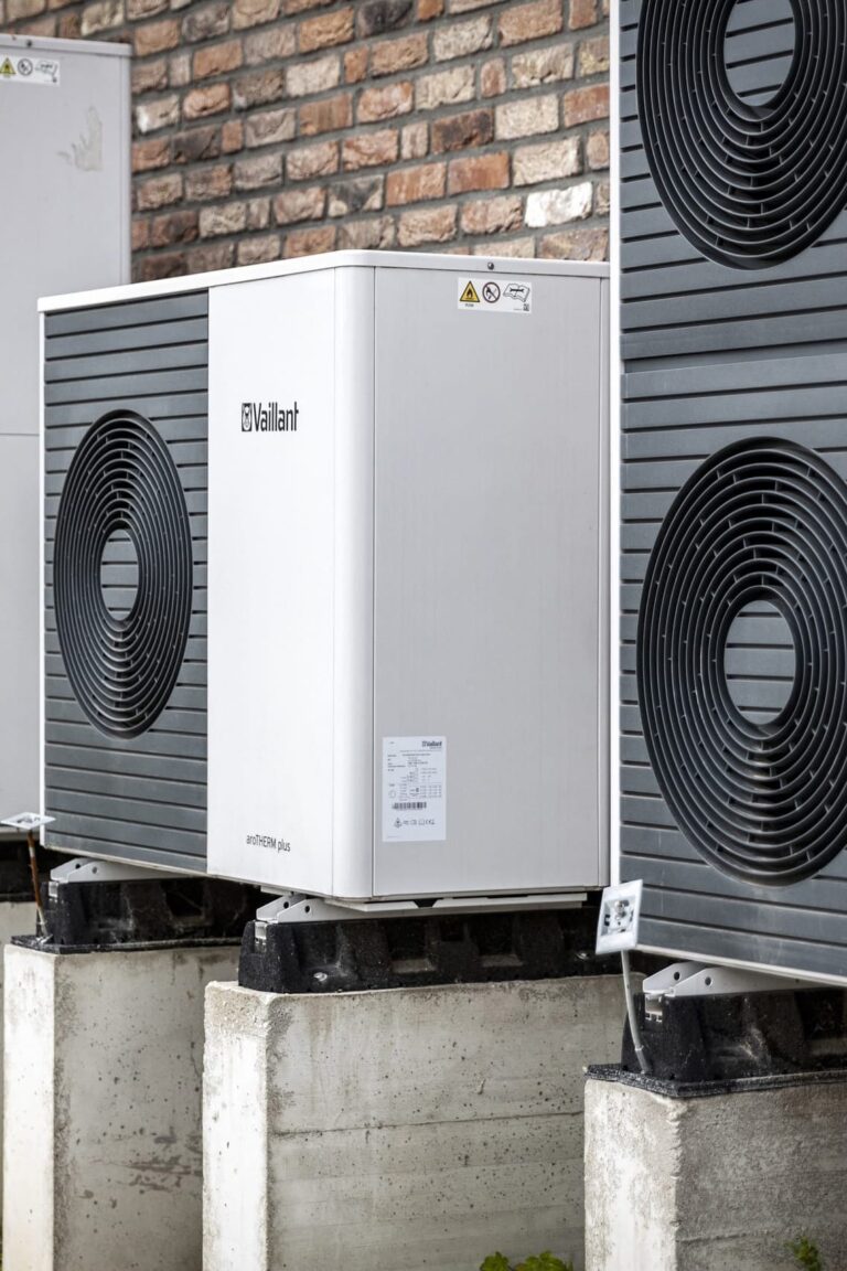 Moderne Wärmepumpe vor Ziegelwand installiert.