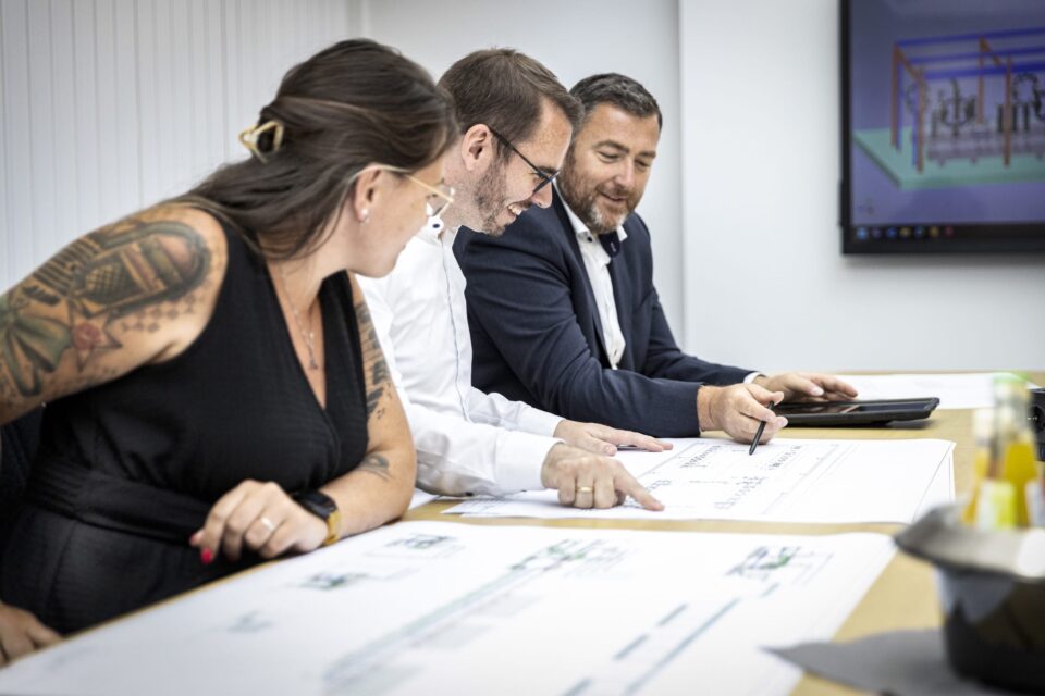 Team analysiert technische Zeichnungen im Büro